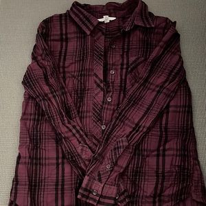 Purple and black plaided button up shirt with front pocket.